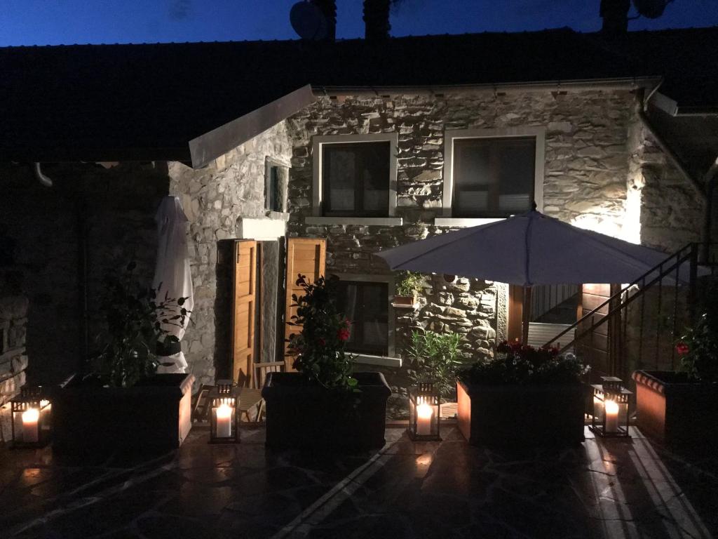 a patio with an umbrella and lights in front of a building at Relais San Filippo in Sogaglia in Mulazzo