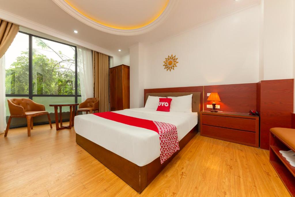 a bedroom with a bed and a table and a chair at Super OYO Capital O 387 Bach Duong Hotel in Hanoi