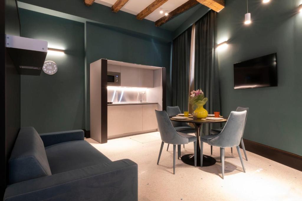 ein Wohnzimmer mit einem Sofa und einem Tisch mit Stühlen in der Unterkunft Residence Poli Venezia in Venedig