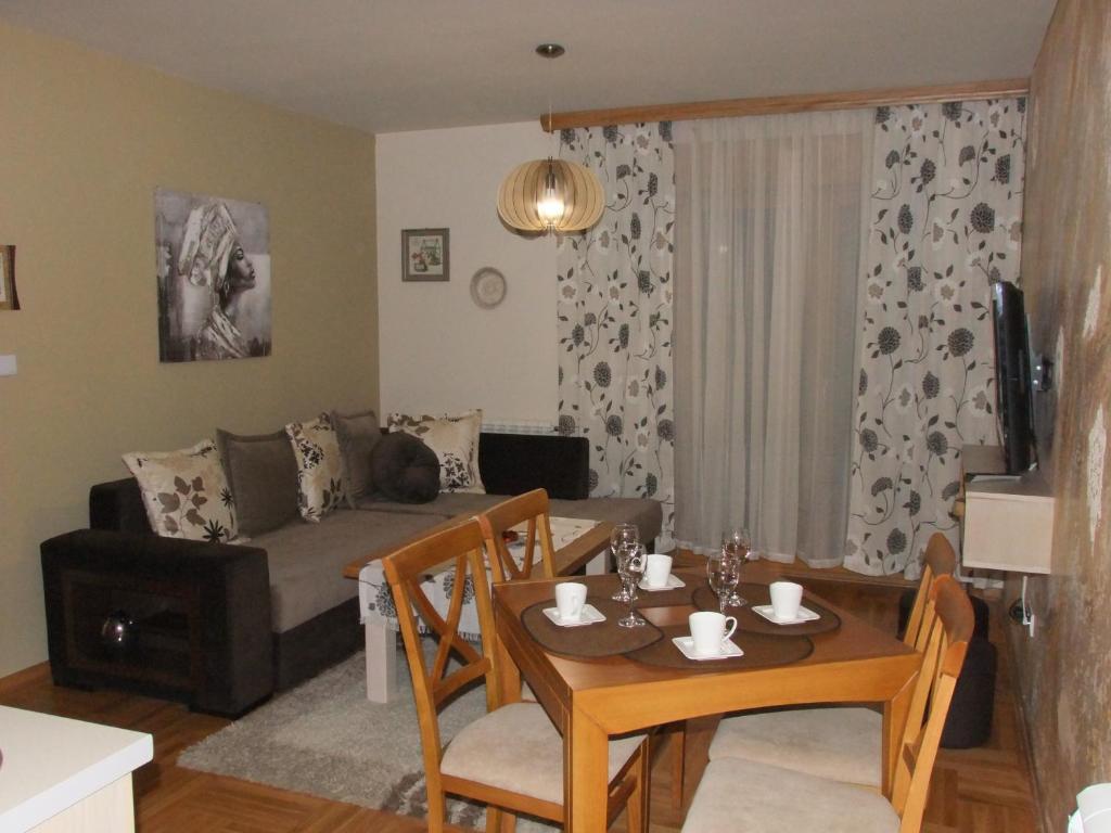 a living room with a table and a couch at Apartman Lara,Zlatibor in Zlatibor