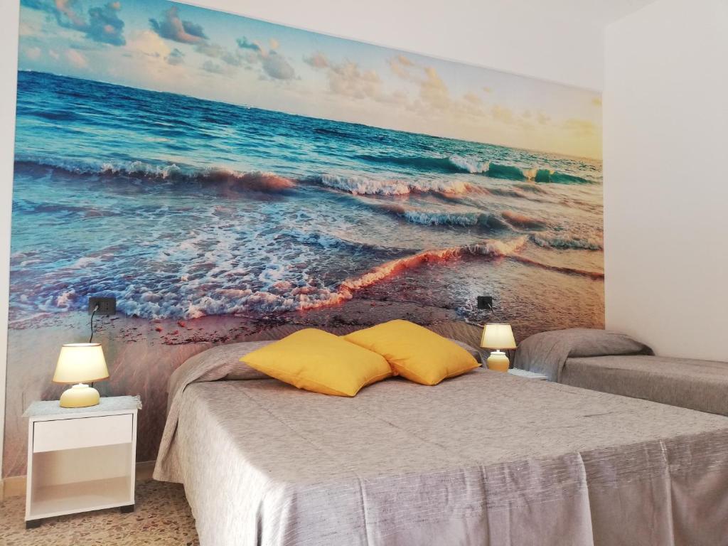 ein Schlafzimmer mit einem Gemälde des Ozeans in der Unterkunft Appartamento City in Palmi