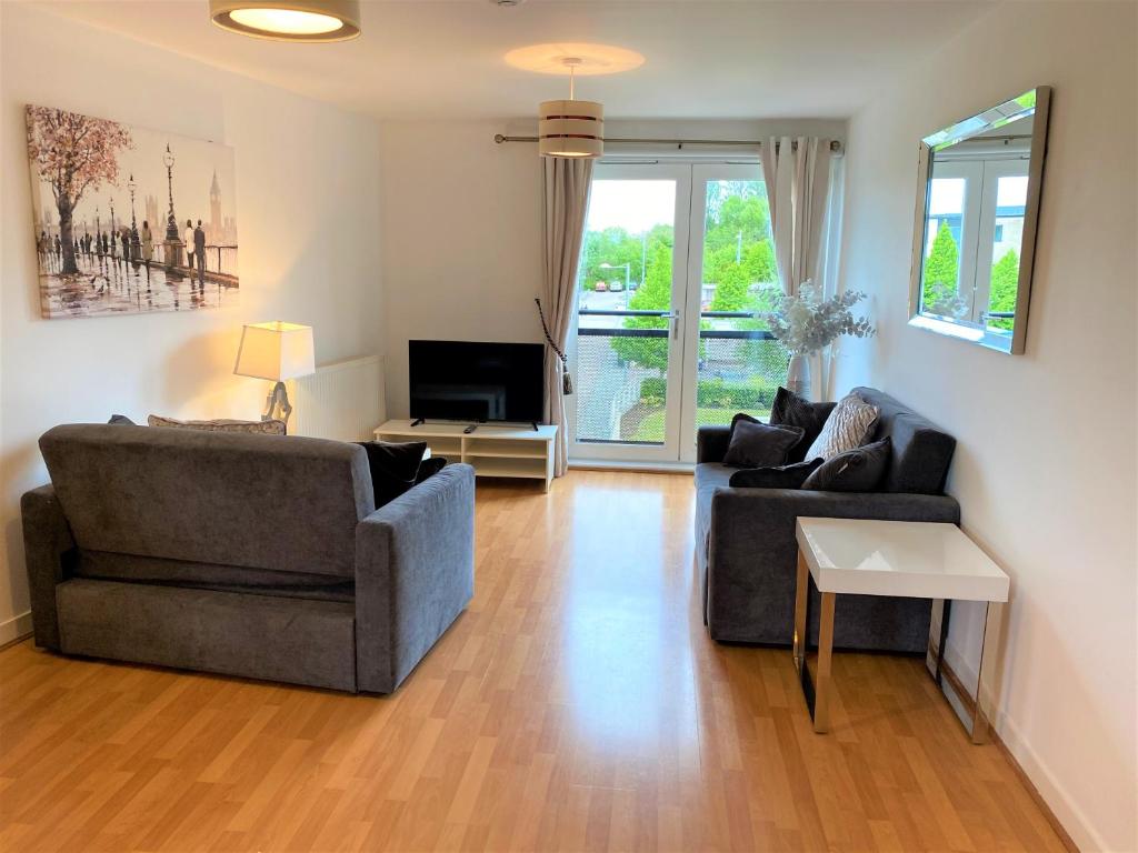 a living room with two couches and a television at Firpark City Apartment - 2 Bedrooms in Glasgow