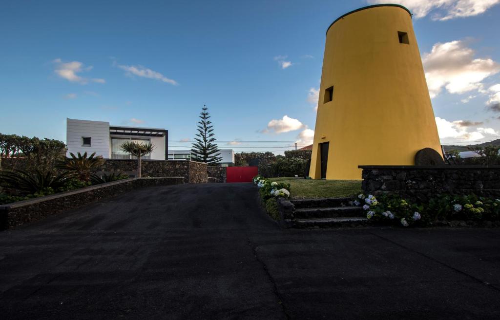 a yellow lighthouse on the side of a road at Wellshouses in Capelas