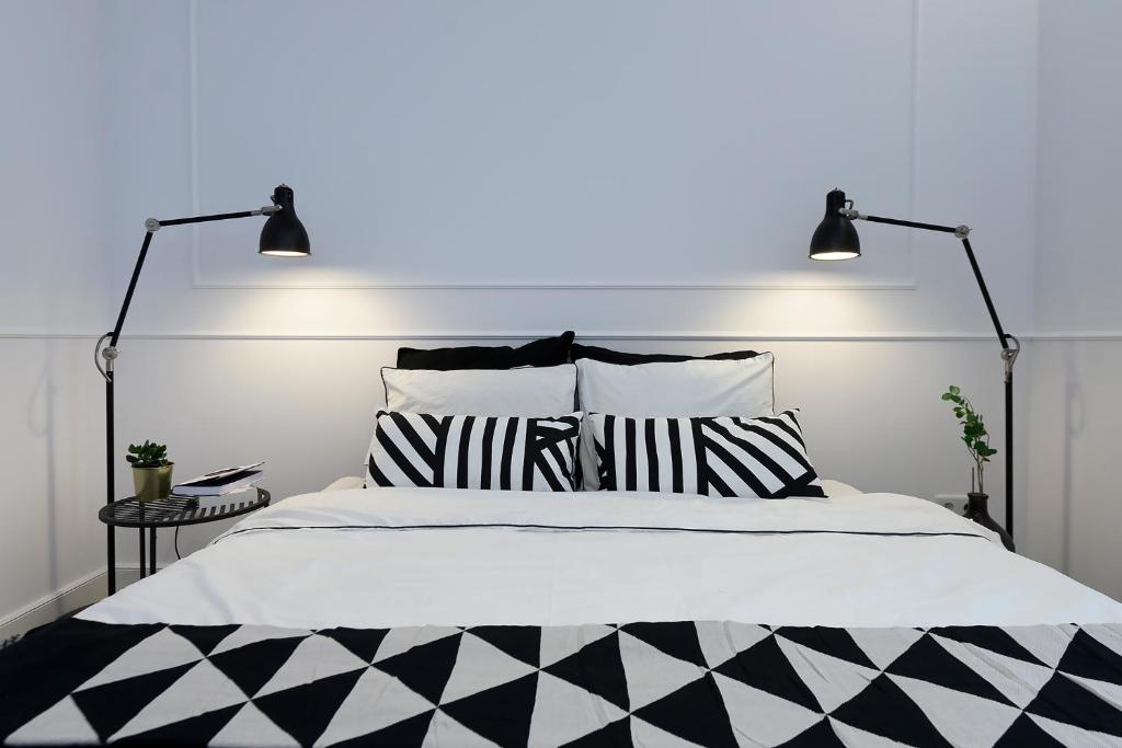 a bedroom with a bed with black and white pillows at Marina Glamour - 3pok, widok na jezioro, klimatyzacja, parking podziemny, winda, Netflix in Iława
