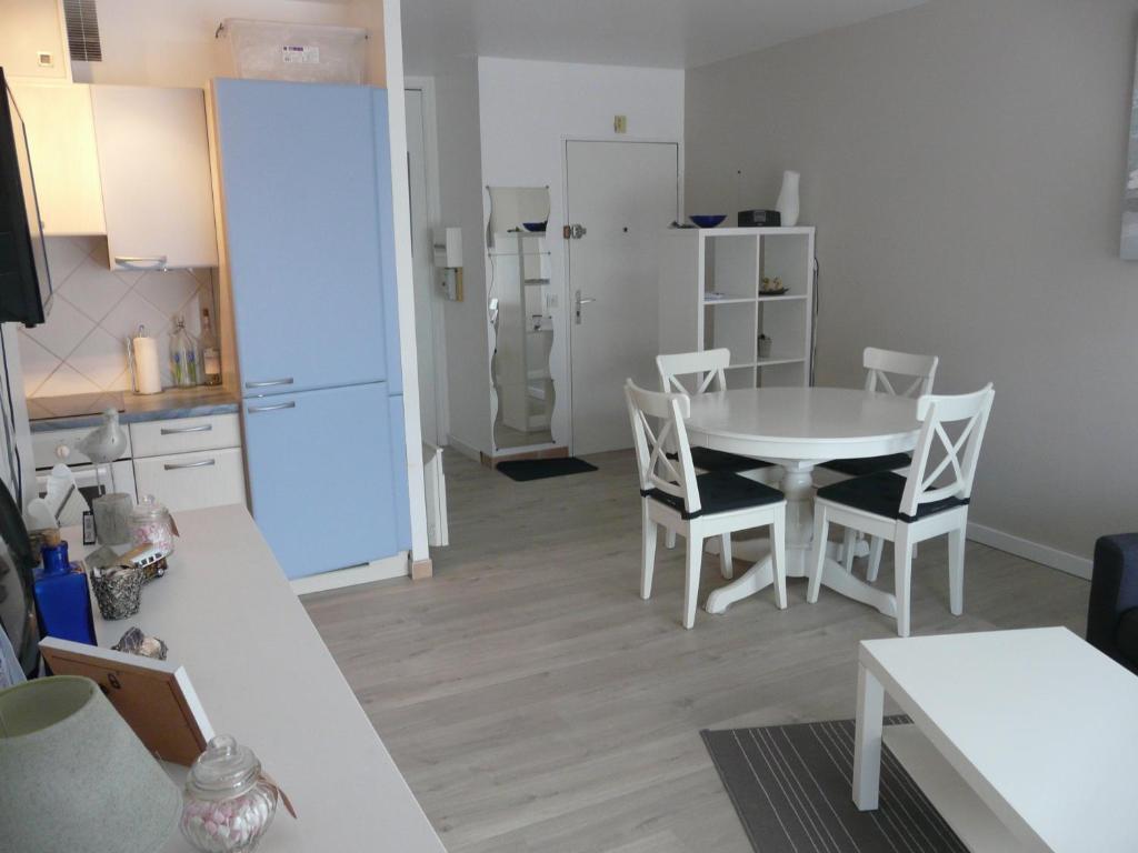 - une cuisine et une salle à manger avec une table et des chaises dans l'établissement RESIDENCE LES BAINS HOULGATE, à Houlgate