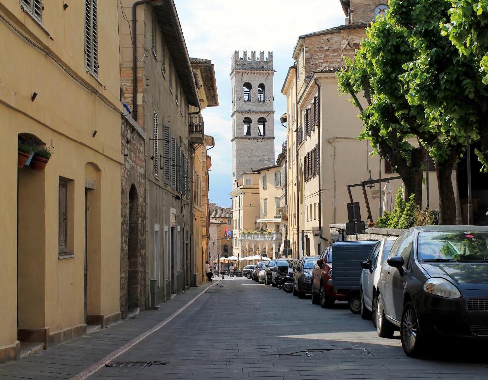 une rue avec des voitures garées sur le côté d'un bâtiment dans l'établissement Alter Ego b&b Assisi, à Assise