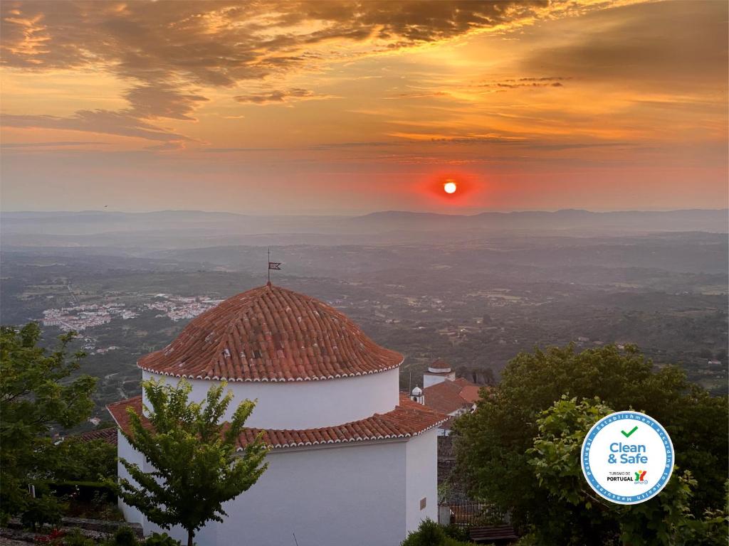 a church with the sunset in the background at Varanda Do Alentejo in Marvão