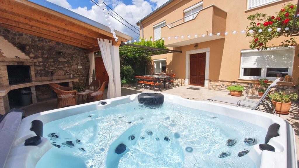 a hot tub in the backyard of a house at Barac Rural Holiday Home in Grižane