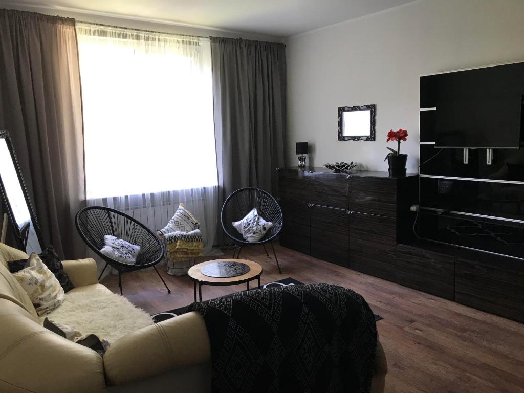 a living room with a couch and chairs and a television at Apartament w Domku in Gdynia