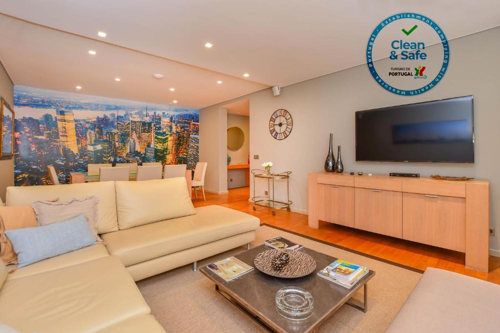 a living room with a couch and a tv at Apartamento Costa Do Sol in Funchal