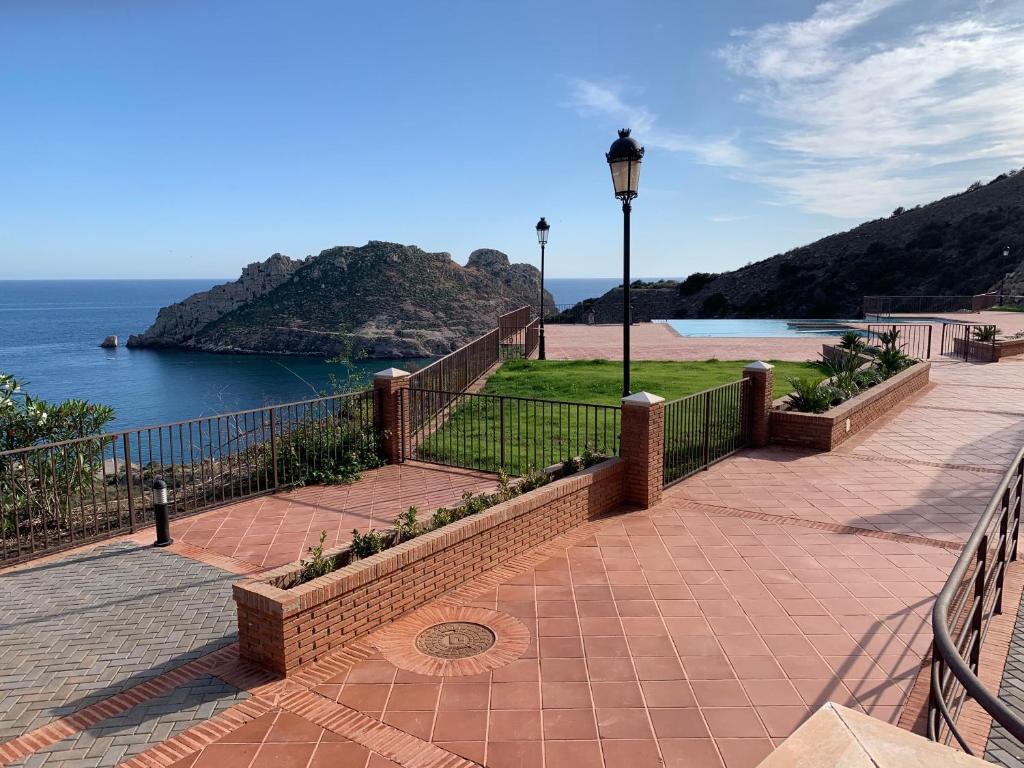 uma passagem com uma cerca ao lado da água em Piso 3 dormitorios en Isla del Fraile con terraza y vistas al mar em Águilas