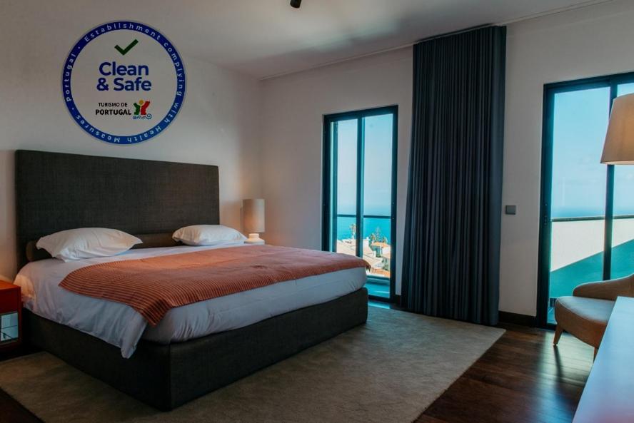 a bedroom with a large bed with a view of the ocean at Vilas Mediterrâneo in Santa Cruz