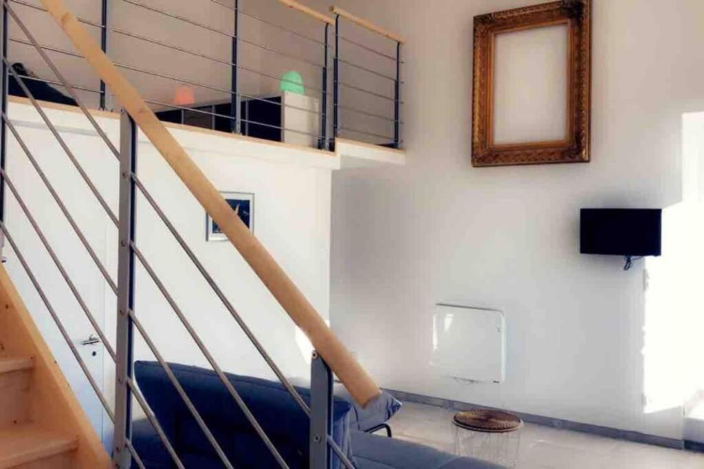 une pièce avec un escalier avec un canapé bleu et un miroir dans l'établissement Le Grand Mole - 2 à 8 voyageurs, à Sète