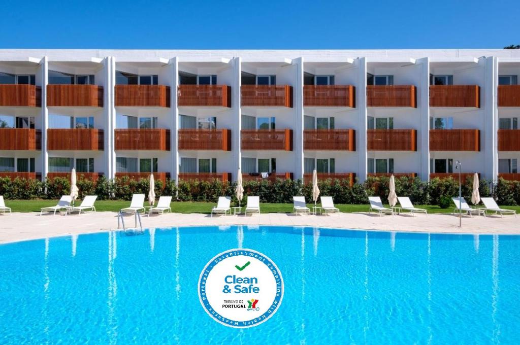 un hôtel avec une grande piscine en face d'un bâtiment dans l'établissement Malibu Foz Hotel - La Maison Younan, à Figueira da Foz