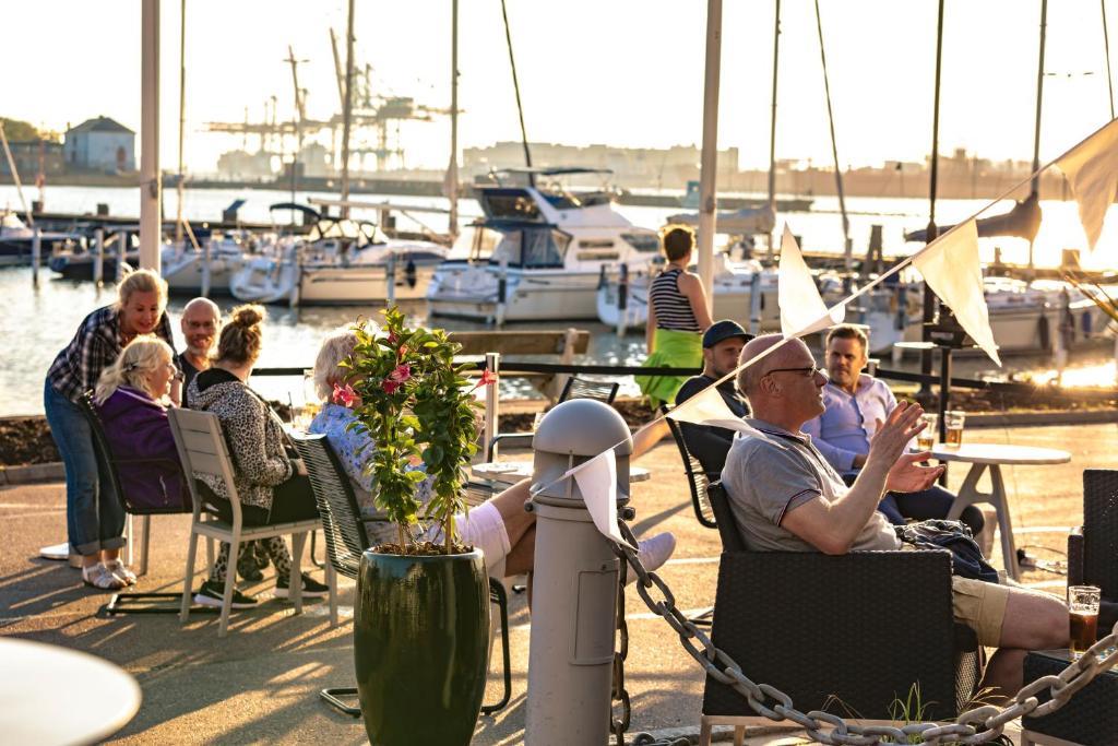
a number of people sitting on chairs at a dock at Dockyard Hotel in Gothenburg
