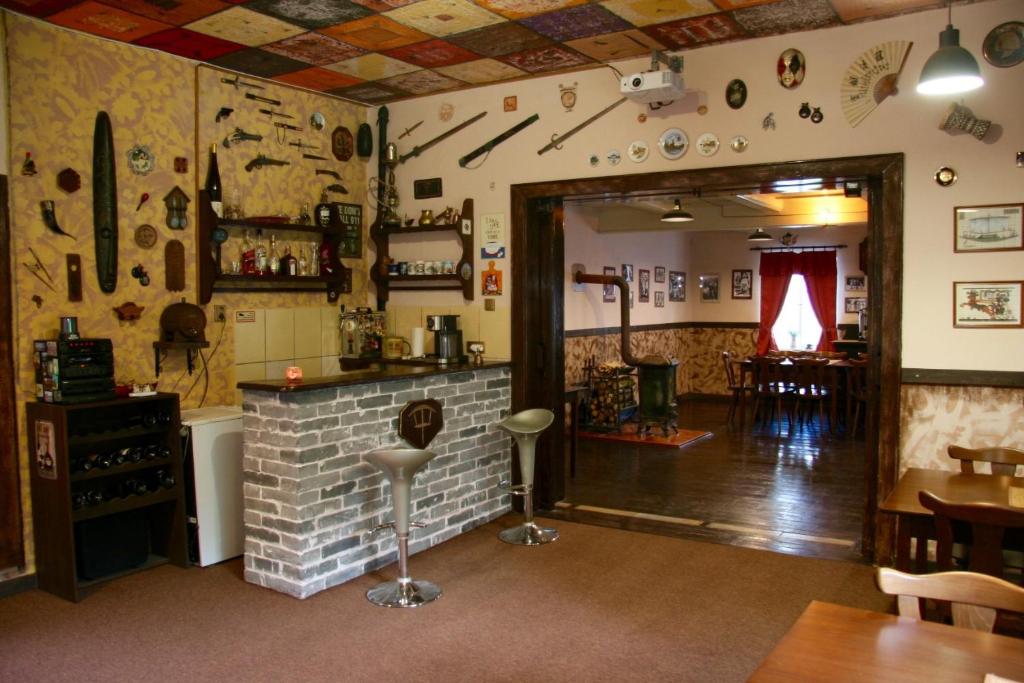 ein Restaurant mit Bar und ein Zimmer mit Kamin in der Unterkunft Villa Sunshine / Slunečna Vila in Krásná Lípa