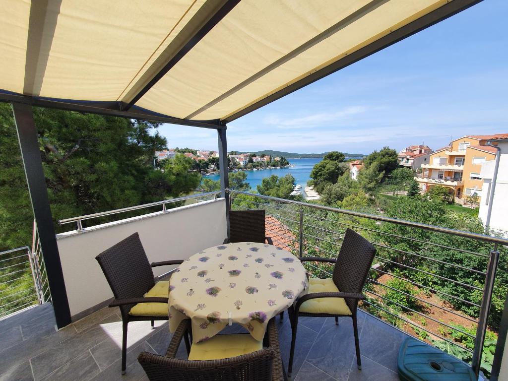 einen Balkon mit einem Tisch und Stühlen sowie Blick auf das Wasser in der Unterkunft Apartments Stella in Zaboric