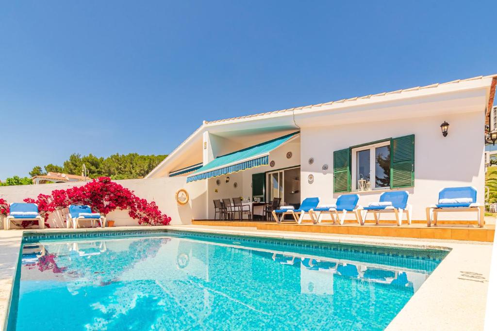 a villa with a swimming pool in front of a house at Villa Noelia in Santo Tomás