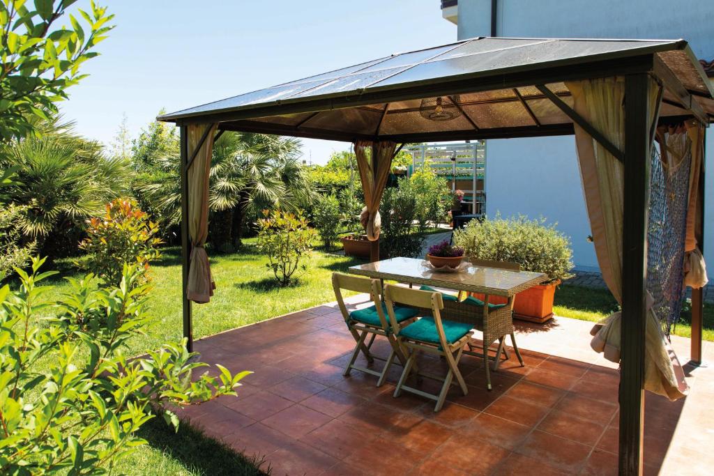 a gazebo with a table and chairs on a patio at Casa "La Conchiglia" in Civitanova Marche