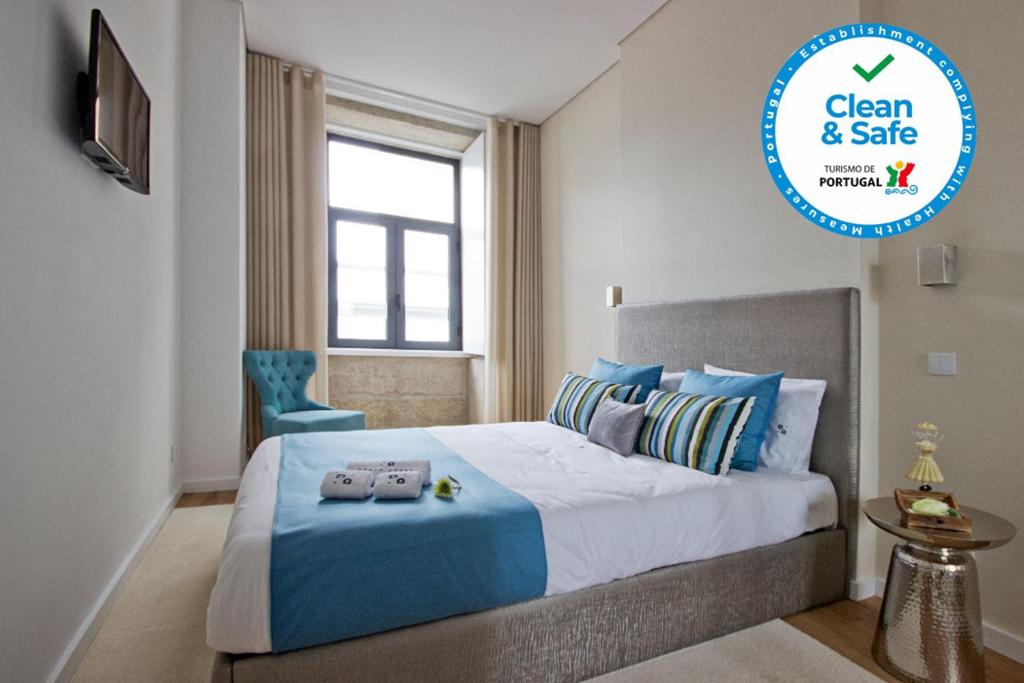 een slaapkamer met een blauw en wit bed en een raam bij OHH -Porto 4 you- Deluxe Apartment With Free Parking in Porto