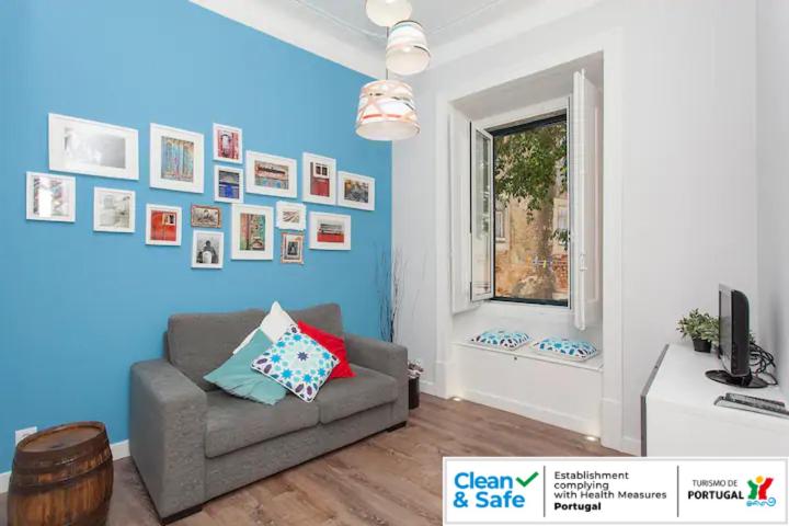 a living room with a couch and a window at Casa das Olarias in Lisbon