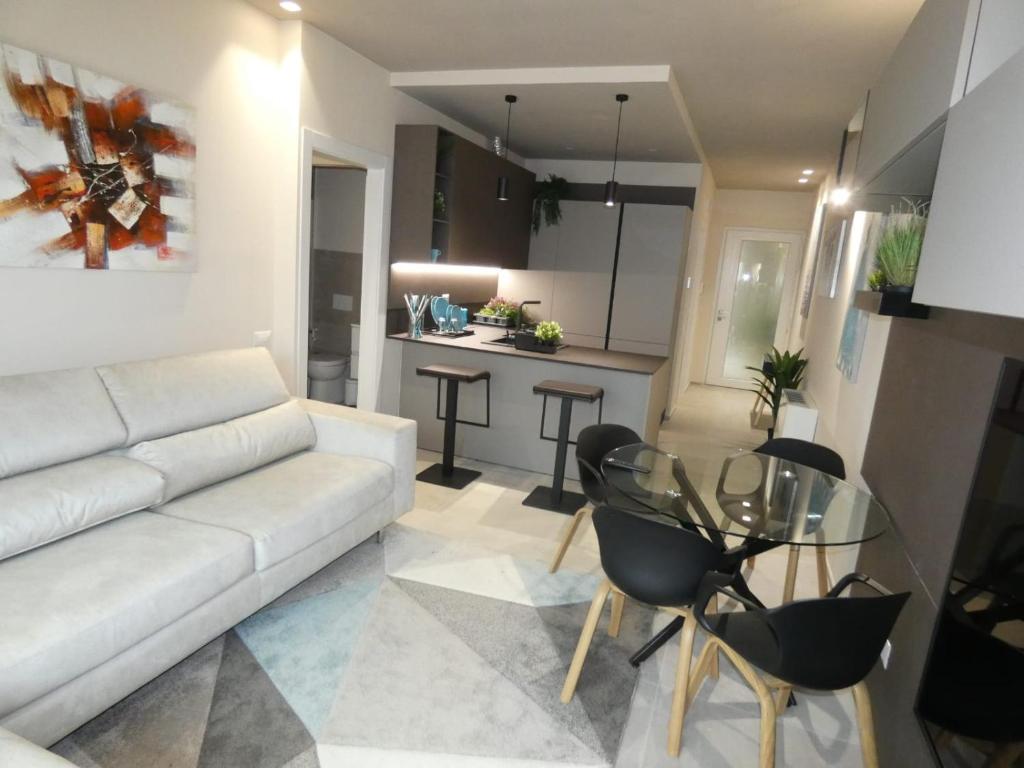 un soggiorno con divano bianco e tavolo in vetro di Town-Beach Home a Civitanova Marche