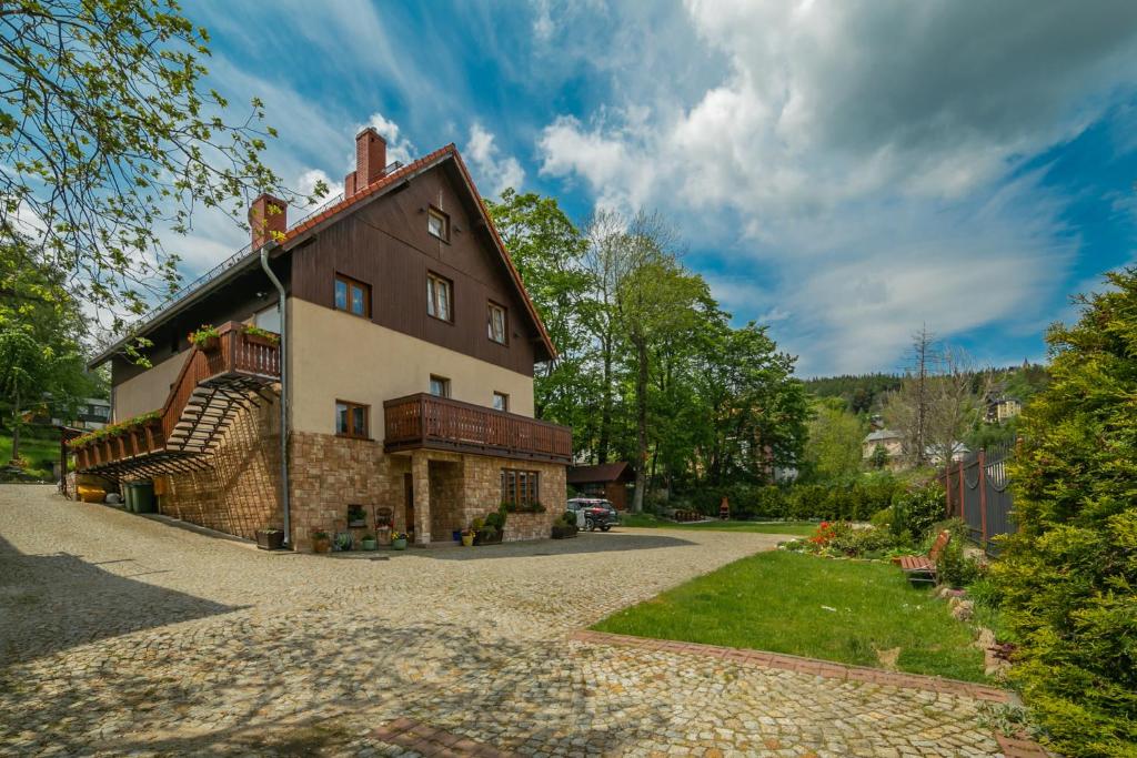 una casa grande con una entrada de piedra delante de ella en Willa Sudety en Karpacz