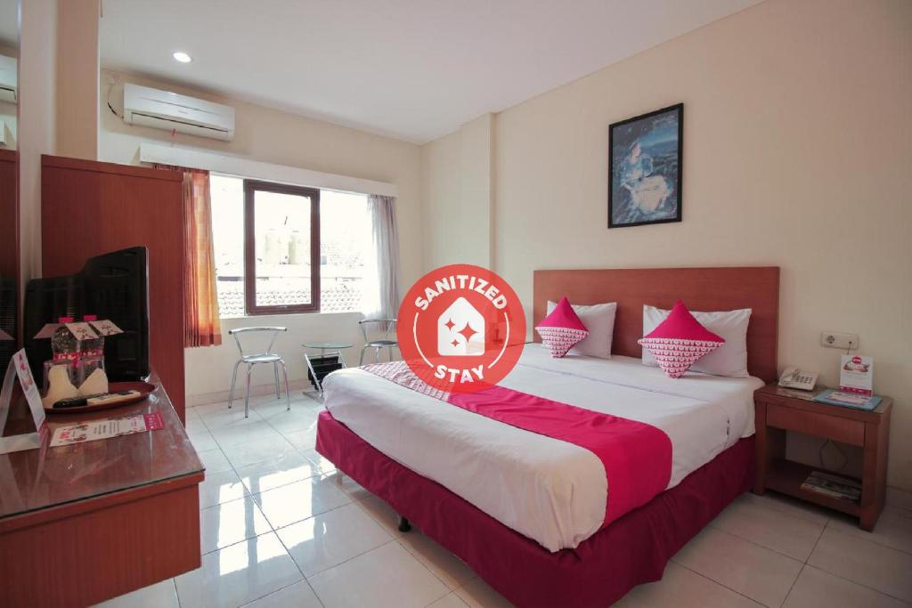 une chambre d'hôtel avec un lit et un panneau. dans l'établissement SUPER OYO Capital O 1511 Galaxy Inn, à Bandung