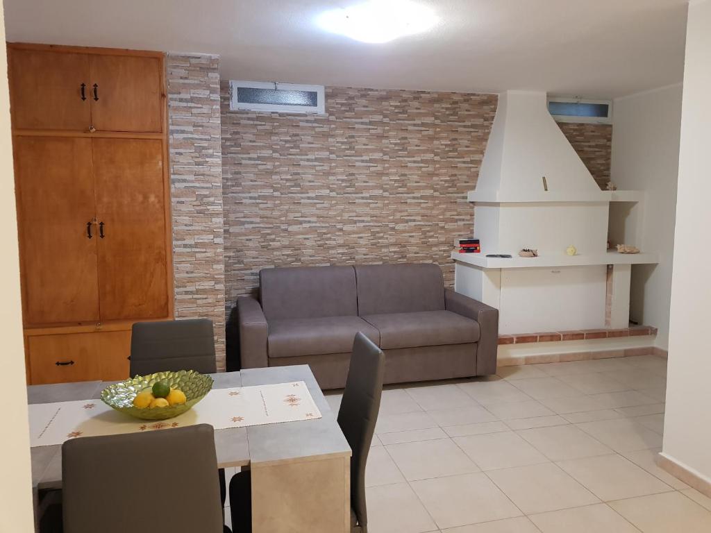 ein Wohnzimmer mit einem Tisch und einem Sofa in der Unterkunft Appartamento Limone in Cala Gonone