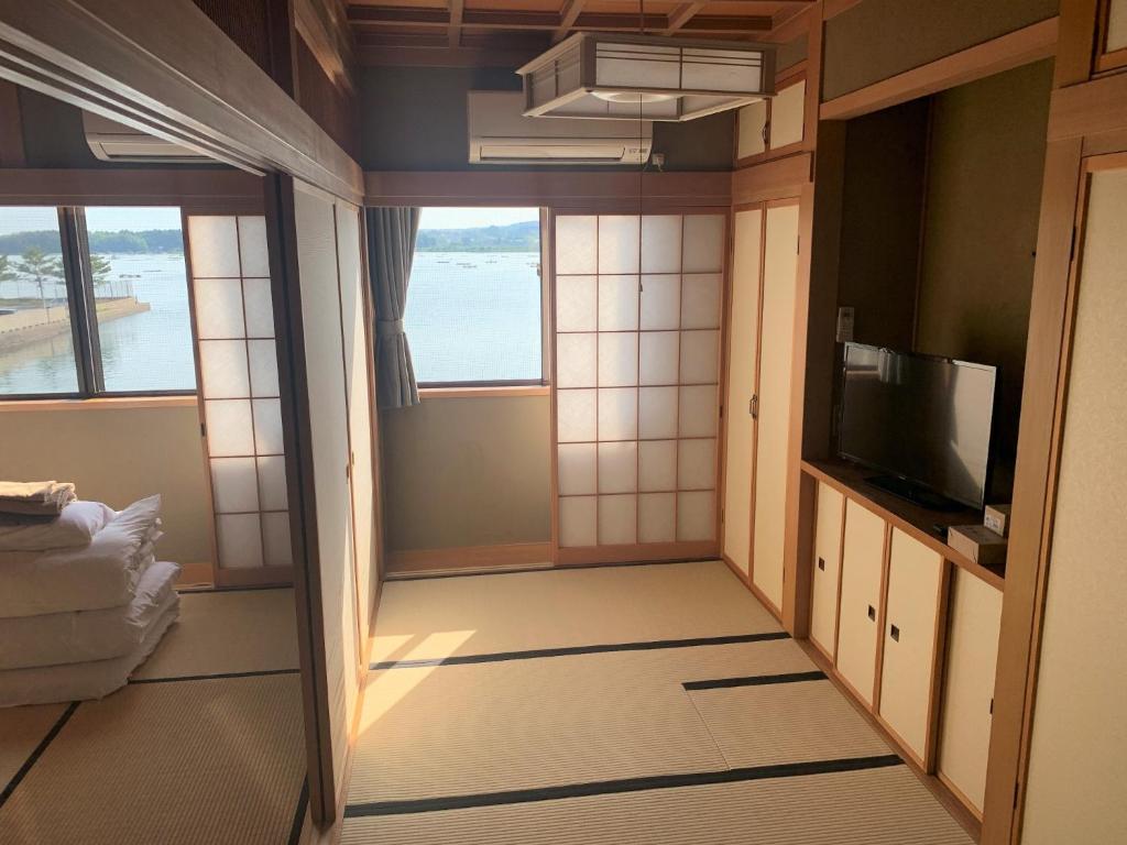 Kleines Zimmer mit einem TV und einem Zimmer mit Aussicht. in der Unterkunft Sado - Hotel - Vacation STAY 82479 in Sado