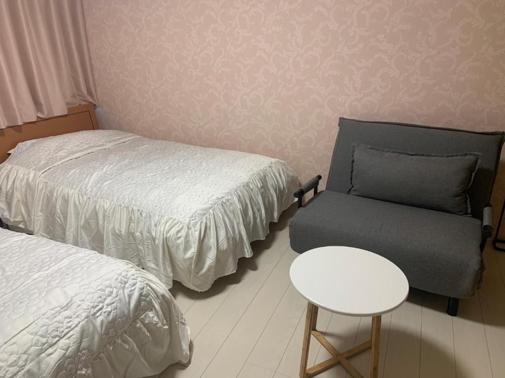 a bedroom with a bed and a chair and a table at Sado - Hotel - Vacation STAY 82476 in Sado