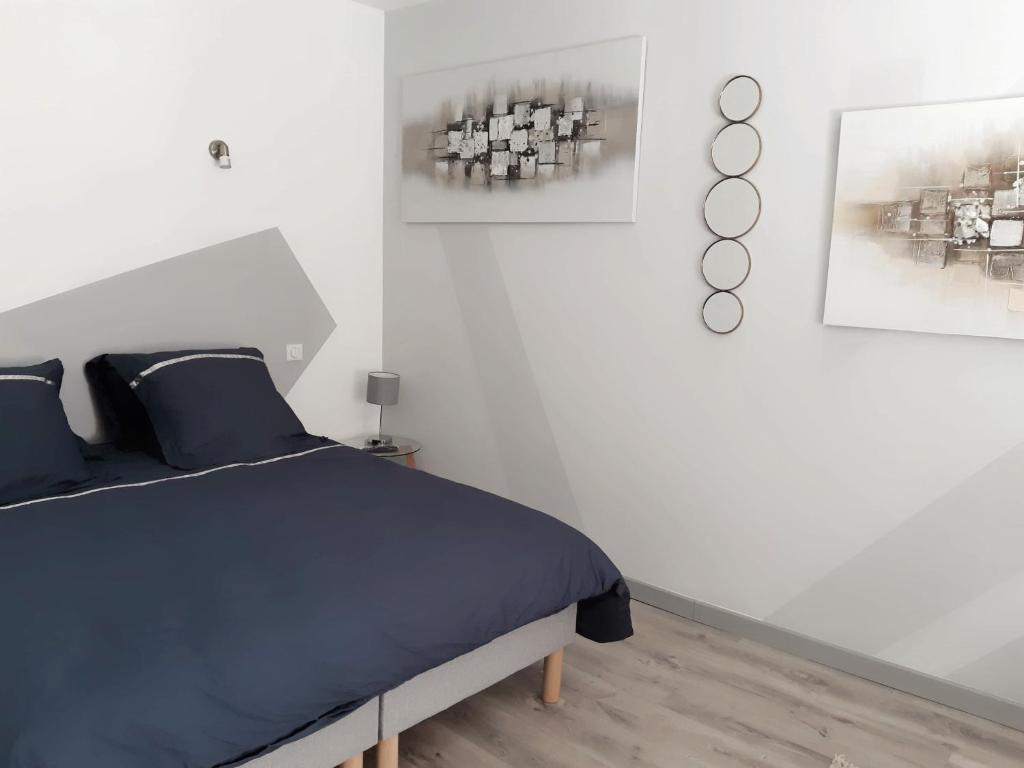 a bedroom with a bed and two pictures on the wall at La Cour in Charleville-Mézières