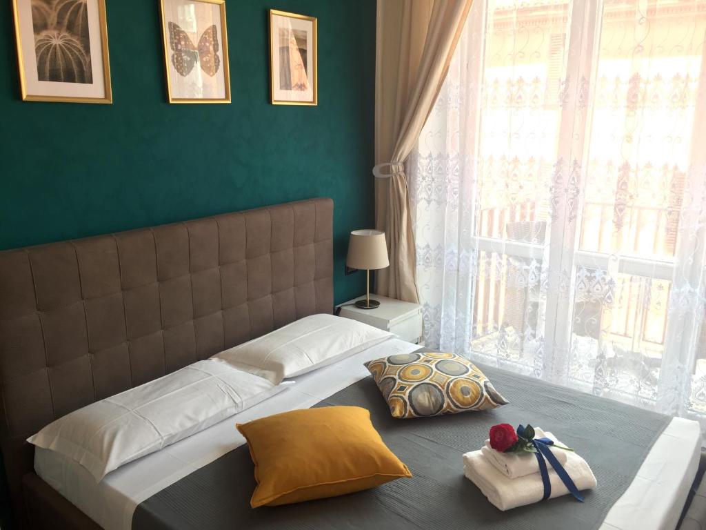 1 dormitorio con 1 cama grande y ventana grande en La Suite Rooms & Apartments en Bolonia