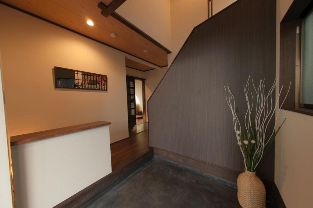korytarz ze schodami i wazonem z rośliną w obiekcie SyukuyaYokohama Main Building 1F - Vacation STAY 82573 w mieście Kitagatamachi