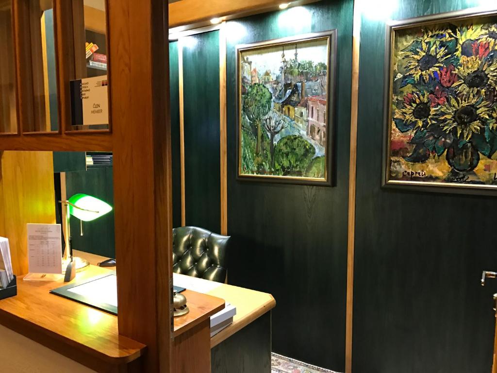 an office with a desk and paintings on the wall at Antik Hotel Sofia in Litomyšl