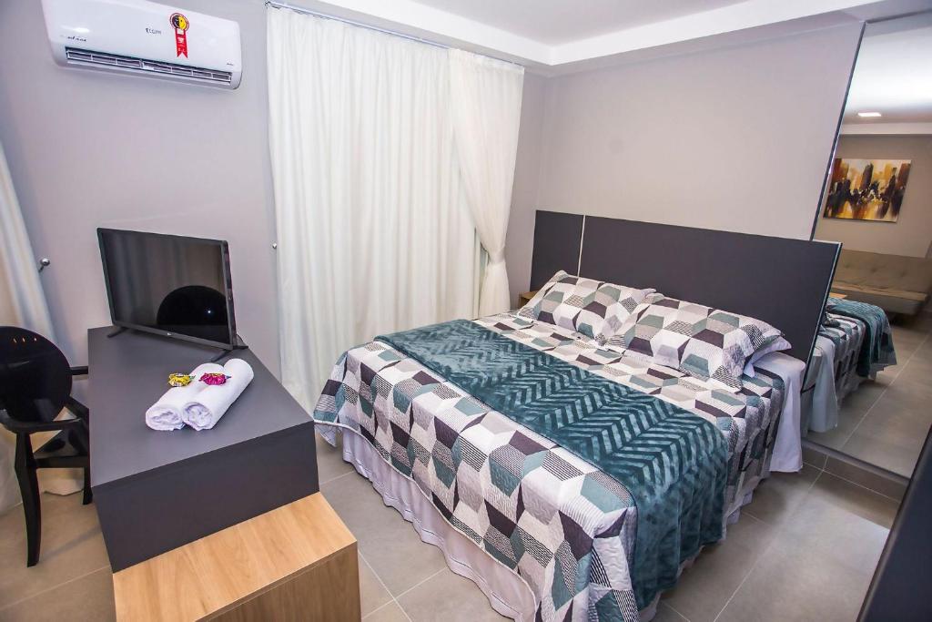 a bedroom with a bed and a tv in it at Studio Andar Alto e Face Norte - ALL1611 in Curitiba