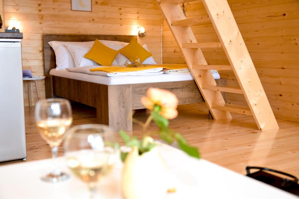une chambre avec un lit et des verres à vin sur une table dans l'établissement Cottage Lana, à Jajce