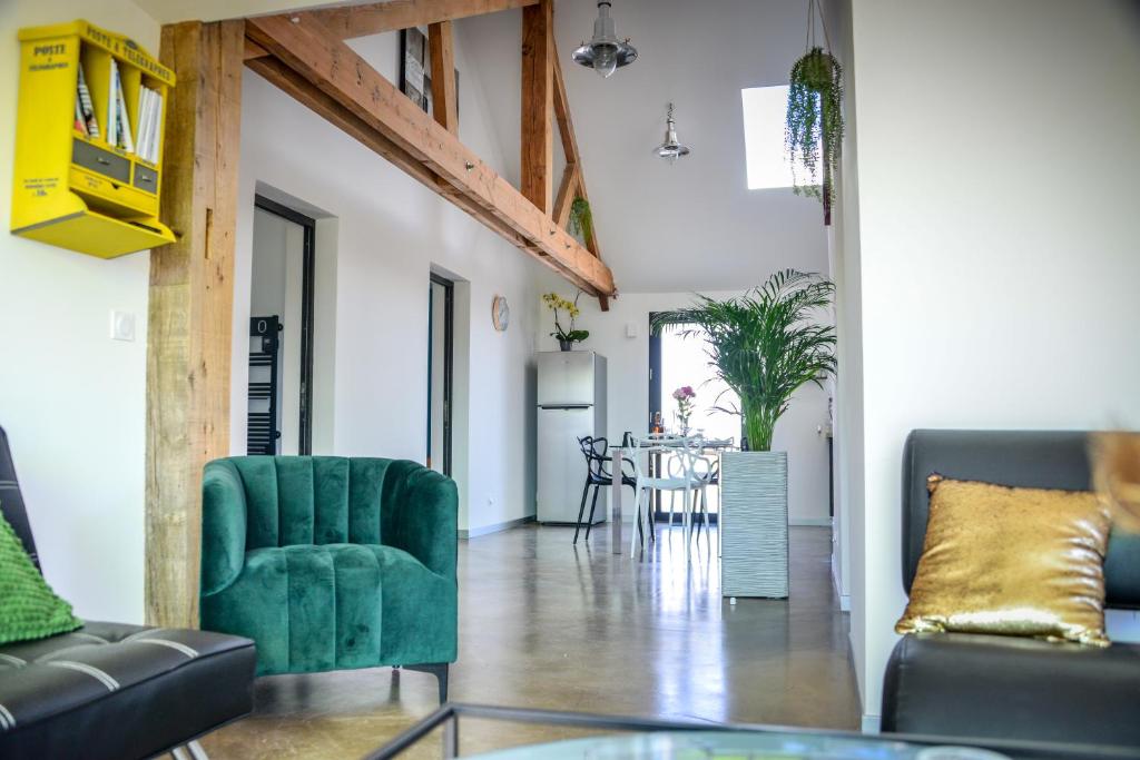 a living room with a green couch and a table at détente et confort - gite baie bocage in Sartilly