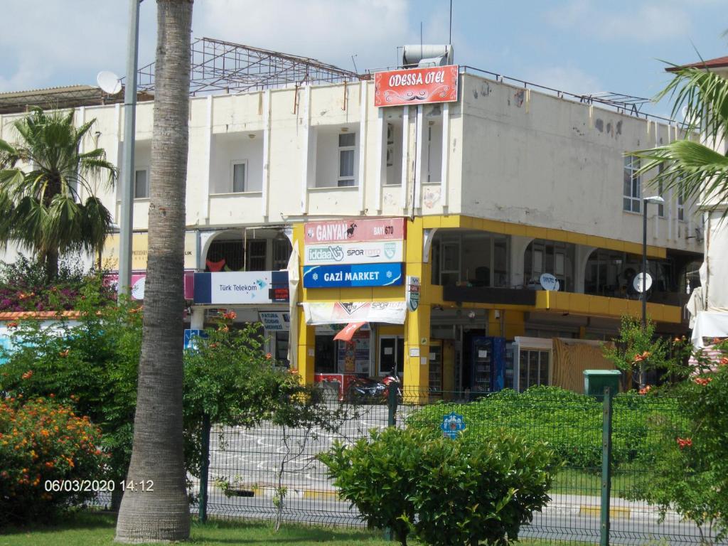 un edificio blanco con un cartel en el costado en Odessa Otel Avsallar, en Avsallar