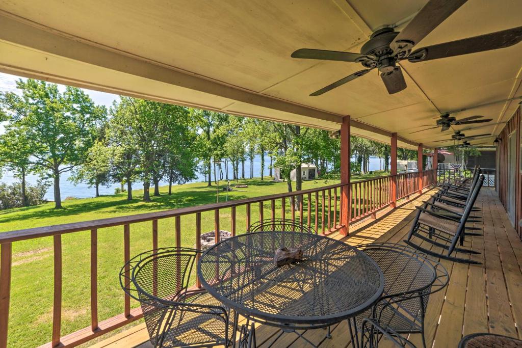 eine Veranda mit Stühlen, einem Tisch und einem Deckenventilator in der Unterkunft Waterfront Tennessee Home on Kentucky Lake with Deck in Durham Subdivision