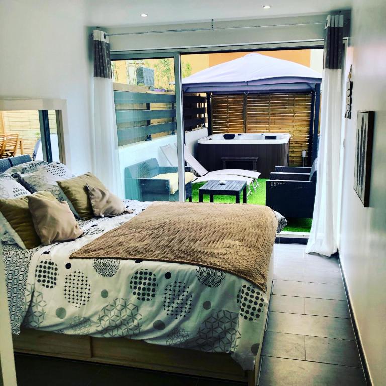 - une chambre avec un lit et une vue sur une terrasse dans l'établissement Cap Paradise suite jacuzzi, au Cap d'Agde
