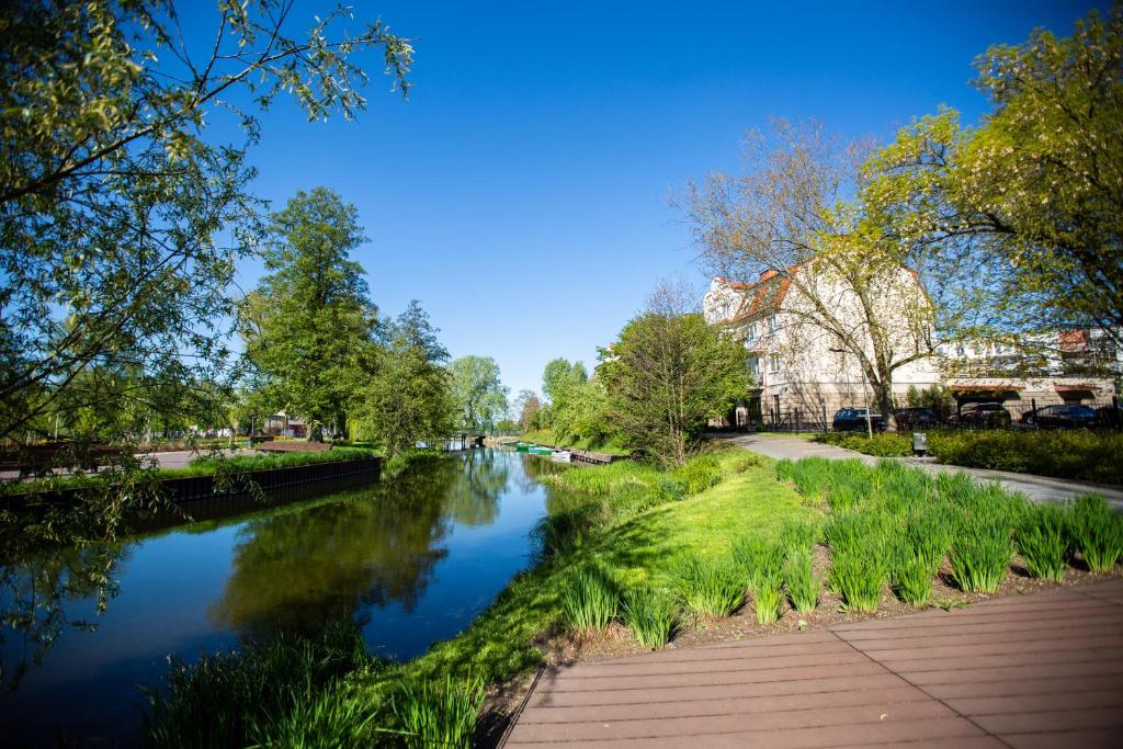 - une vue sur une rivière avec des bâtiments et des arbres dans l'établissement Apartament Masuria, à Ełk