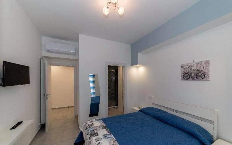 1 dormitorio con 1 cama azul y TV en B&B Orchidea en Salerno