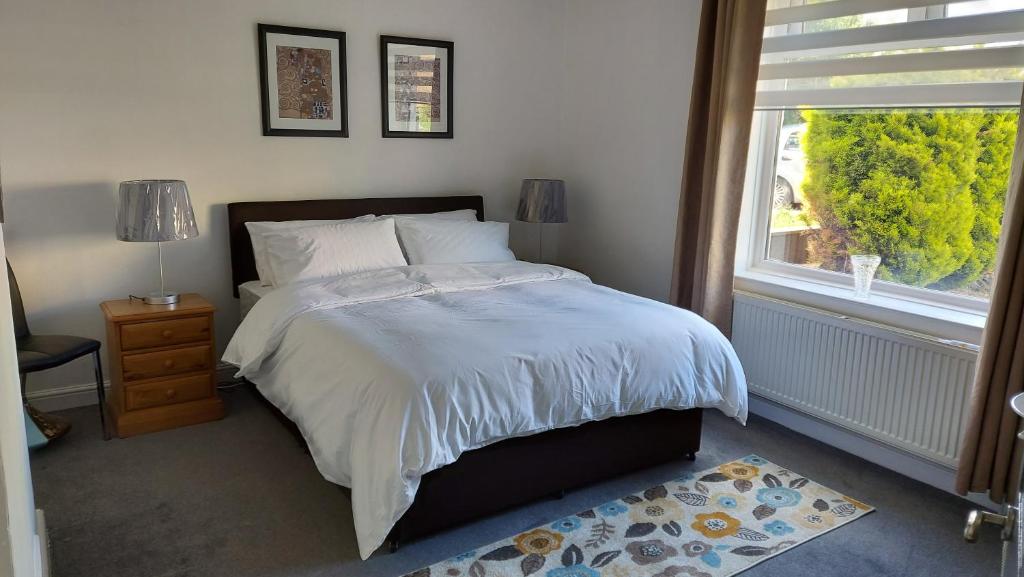 a bedroom with a large bed and a window at LAWFIELD R&R in West Kilbride