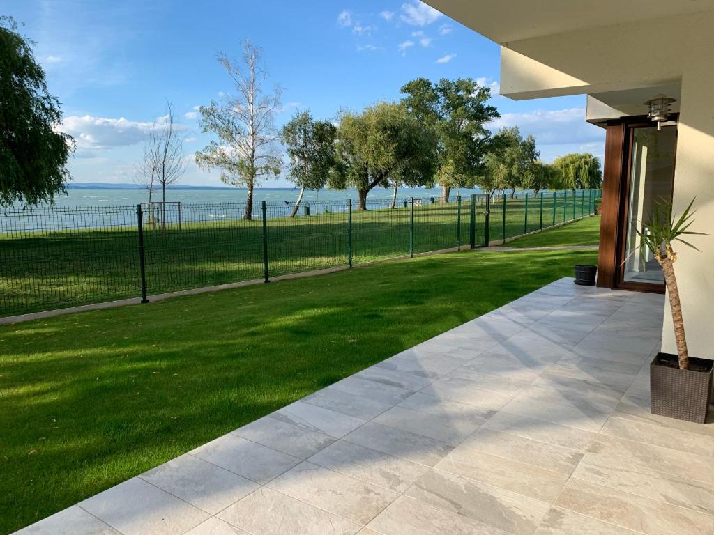 a walkway next to a field of grass with a fence at F5 in Siófok