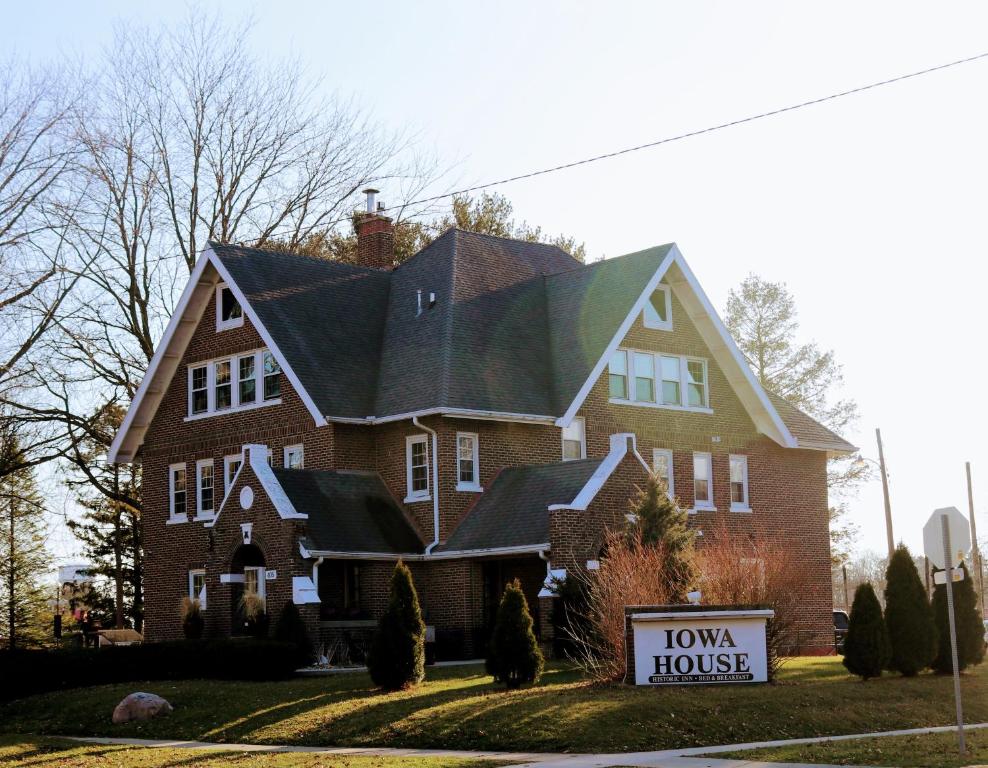 a large house with a sign in front of it at Iowa House Historic Inn in Ames