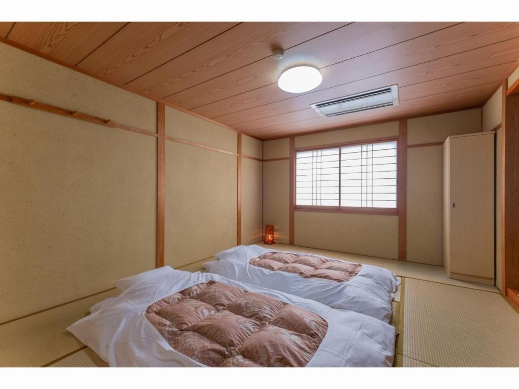 SERENDIP HOTEL GOTO - Vacation STAY 82393 في غوتو: غرفة نوم مع سرير في غرفة مع نافذة