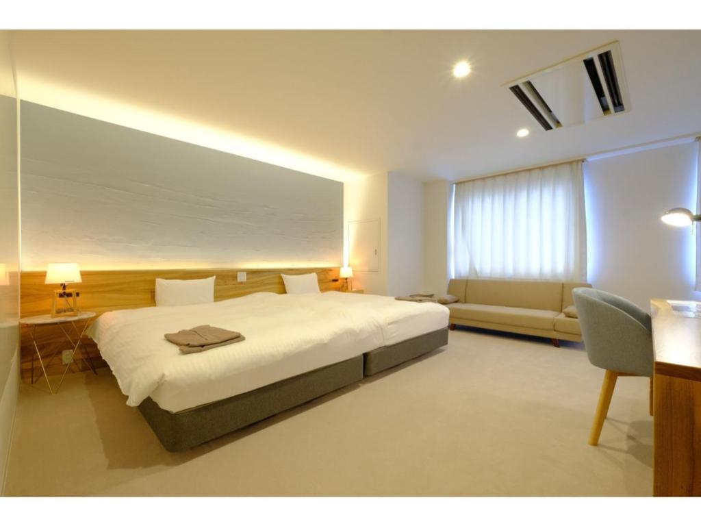 sypialnia z dużym białym łóżkiem i kanapą w obiekcie SERENDIP HOTEL GOTO - Vacation STAY 82543 w Gotō