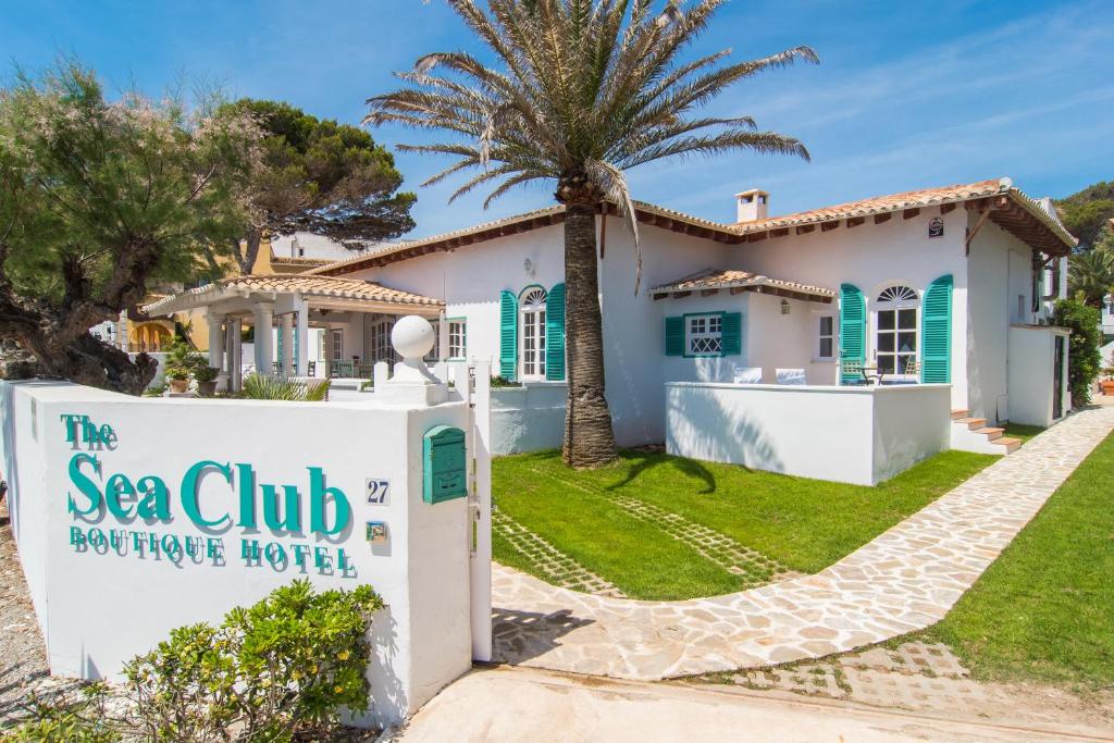 uma villa com uma palmeira e uma residência turística com clube do mar em The Sea Club em Cala Ratjada