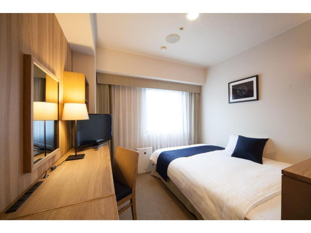 a hotel room with a bed and a flat screen tv at Hotel St Palace Kurayoshi - Vacation STAY 82268 in Kurayoshi